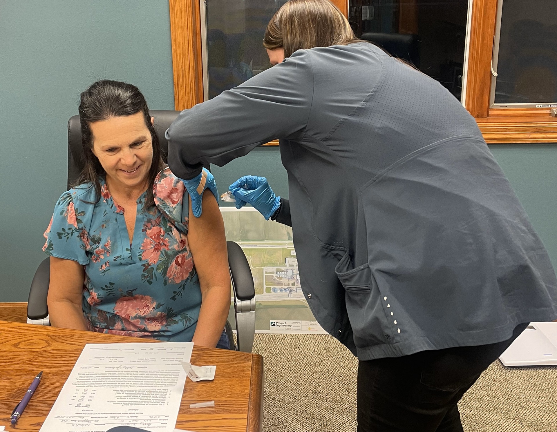 A Mitchell County Public Health patient getting an immunization in the arm from a staff member.